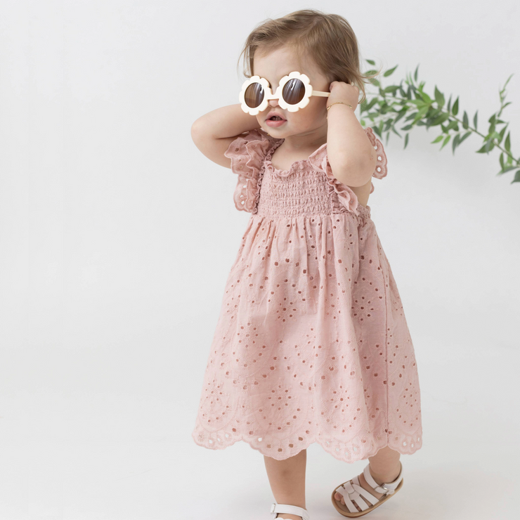 little girl in a pink dress wearing sunglasses
