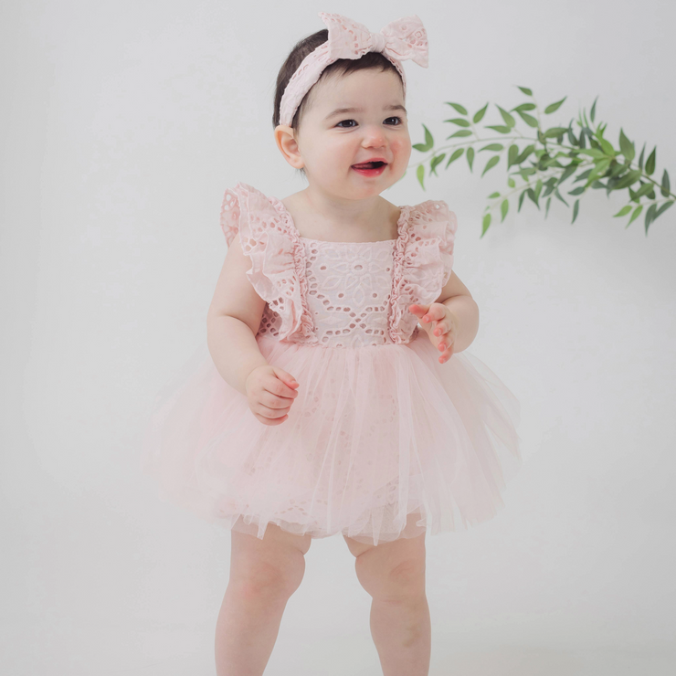 front shot of baby girl wearing pink dress and bow