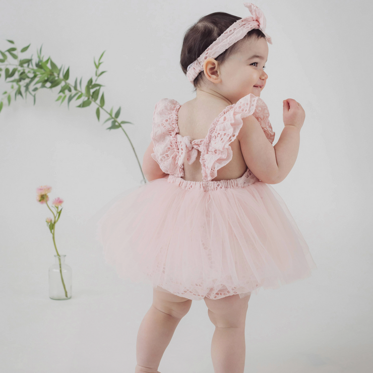 back shot of baby girl wearing pink dress and bow
