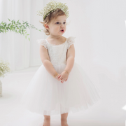 little girl standing wearing white dress